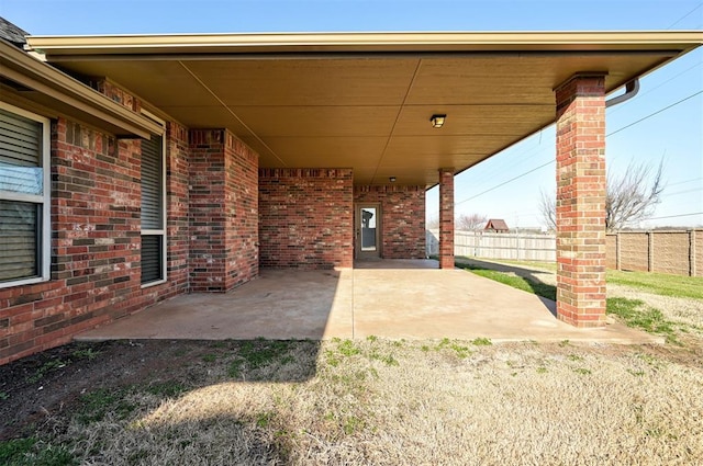 view of patio featuring a carport and fence