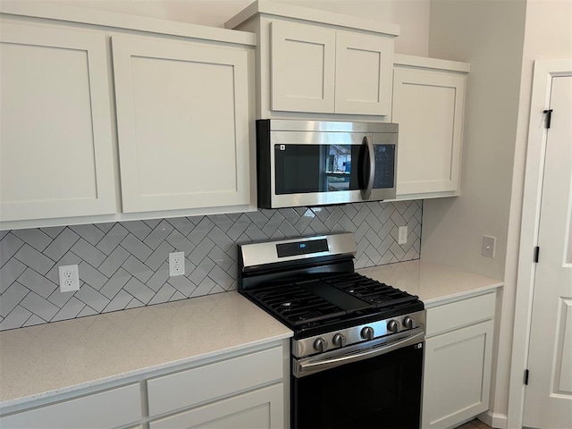 2948 NW 196th Pl, Edmond, OK 73012 - kitchen featuring appliances with stainless steel finishes, backsplash, white cabinetry, and light stone counters