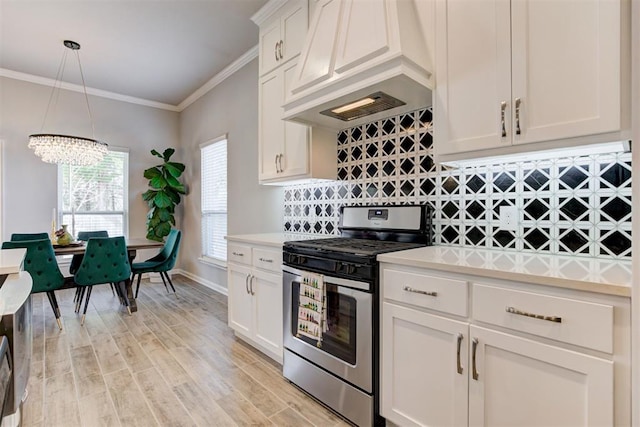 kitchen with an inviting chandelier, light countertops, premium range hood, and gas stove
