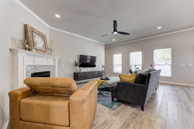 living area with crown molding, ceiling fan, plenty of natural light, and light wood-style floors