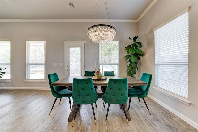dining area featuring baseboards, ornamental molding, an inviting chandelier, visible vents, and light wood-style floors