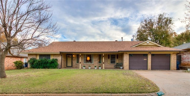 ranch-style house featuring a front yard, an attached garage, brick siding, and driveway