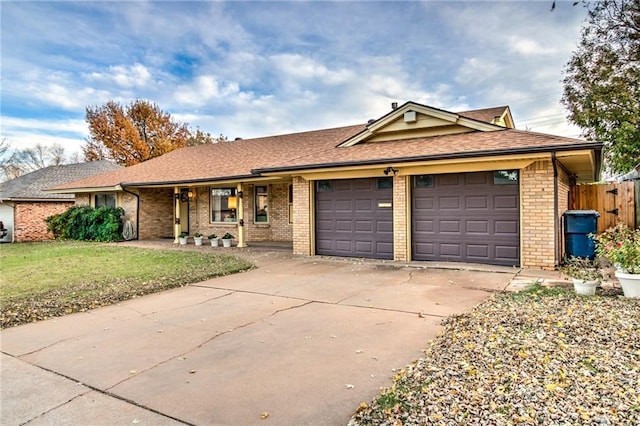 ranch-style house featuring concrete driveway, an attached garage, brick siding, and a front lawn