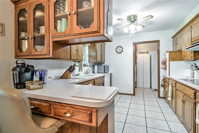 kitchen featuring a ceiling fan, light countertops, and brown cabinetry