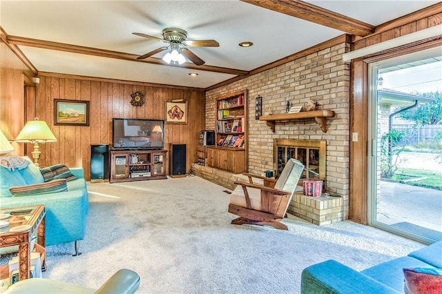 carpeted living area featuring a fireplace, beamed ceiling, a ceiling fan, and wood walls