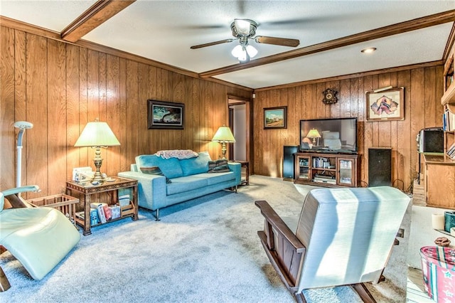 carpeted living area with beamed ceiling, wood walls, and a ceiling fan