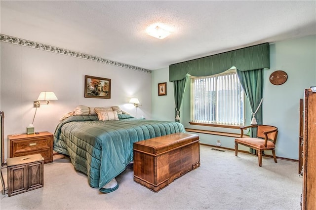 bedroom with visible vents, carpet, baseboards, and a textured ceiling