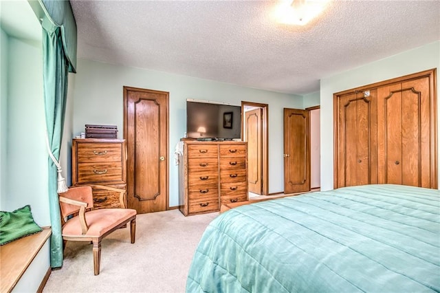 bedroom featuring a textured ceiling and light carpet