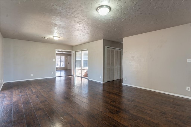 spare room featuring a textured ceiling, baseboards, and hardwood / wood-style floors