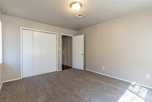 unfurnished bedroom with visible vents, carpet floors, and a decorative wall