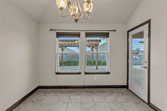 unfurnished dining area with baseboards, lofted ceiling, and a notable chandelier