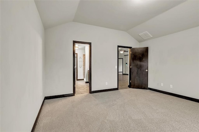 unfurnished bedroom featuring light carpet, visible vents, baseboards, and lofted ceiling