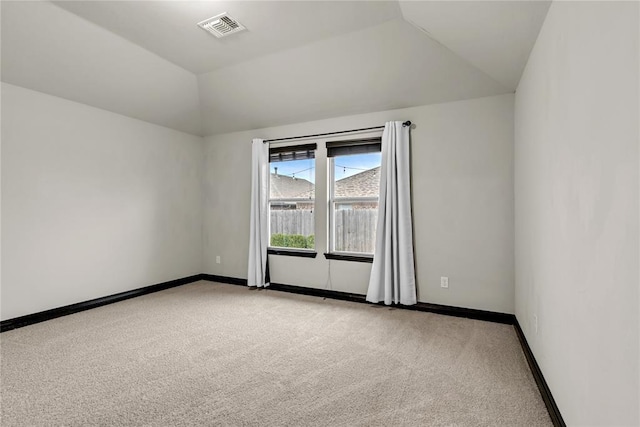 unfurnished room with baseboards, visible vents, lofted ceiling, and carpet floors