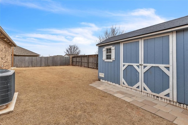 view of yard with a fenced backyard, a shed, cooling unit, and an outdoor structure