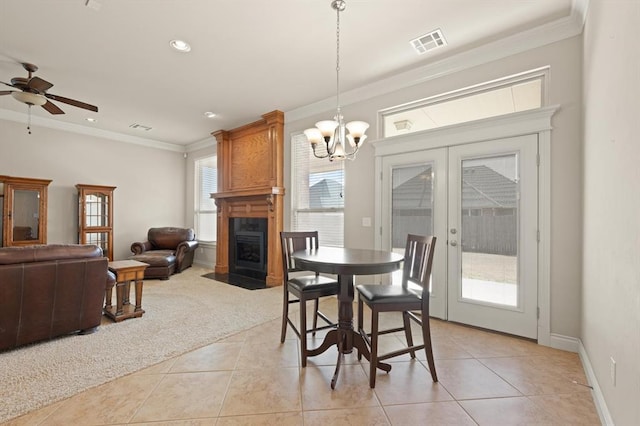 dining room with visible vents, light carpet, french doors, a large fireplace, and crown molding