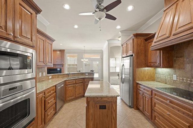 kitchen with brown cabinets, appliances with stainless steel finishes, a peninsula, and crown molding