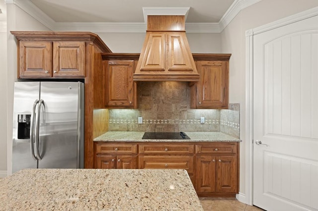 kitchen featuring light stone counters, brown cabinets, and stainless steel refrigerator with ice dispenser