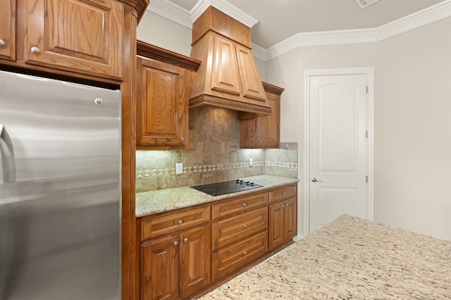 kitchen with black electric stovetop, ornamental molding, tasteful backsplash, and stainless steel refrigerator