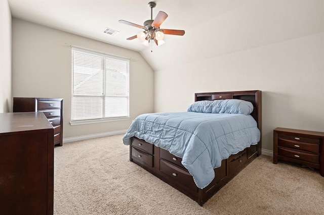 bedroom with lofted ceiling, baseboards, visible vents, and light carpet