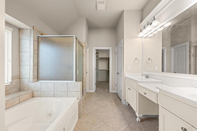 bathroom with tile patterned flooring, double vanity, a stall shower, a tub with jets, and a sink