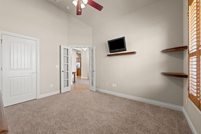 unfurnished bedroom with carpet flooring, french doors, high vaulted ceiling, and baseboards