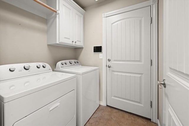 laundry room with light tile patterned floors, cabinet space, and washing machine and clothes dryer