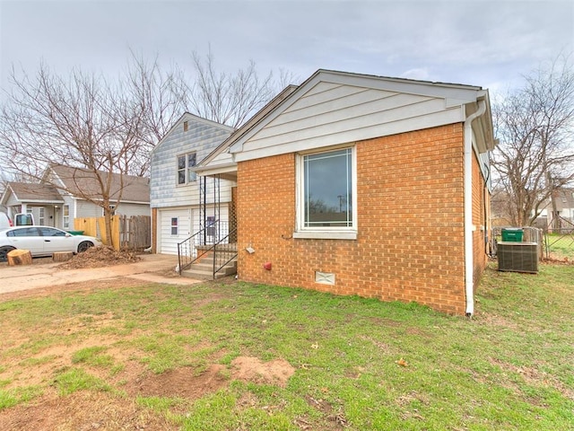 exterior space with brick siding, crawl space, a yard, and fence