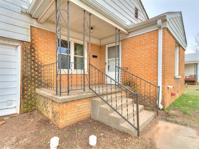 property entrance featuring brick siding and a porch