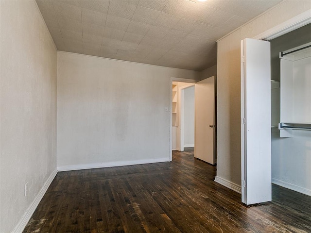 unfurnished room with baseboards and hardwood / wood-style floors