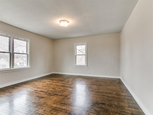 unfurnished room with hardwood / wood-style flooring, baseboards, and a textured ceiling