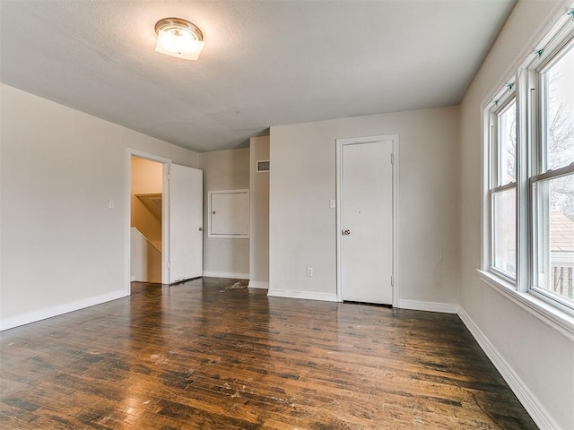 spare room featuring visible vents, baseboards, a textured ceiling, and wood finished floors