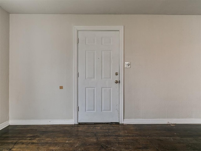 unfurnished room with baseboards and wood finished floors