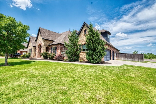 view of front of home featuring fence, concrete driveway, a front lawn, a garage, and stone siding