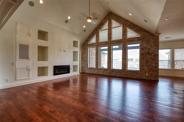 unfurnished living room with built in features, wood finished floors, high vaulted ceiling, ceiling fan, and a glass covered fireplace