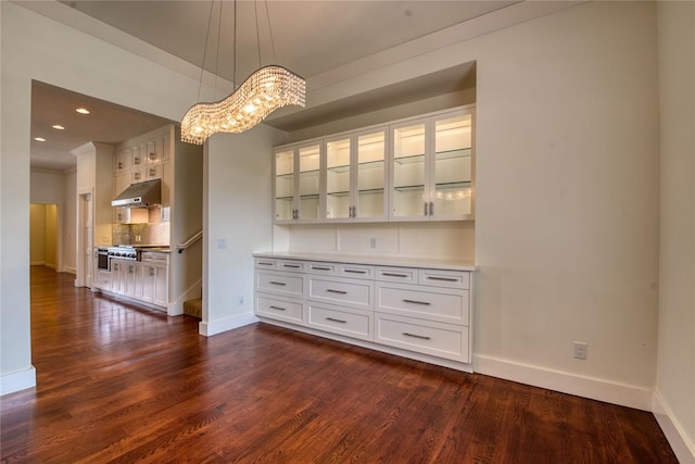 unfurnished dining area featuring a chandelier, recessed lighting, dark wood-type flooring, and baseboards