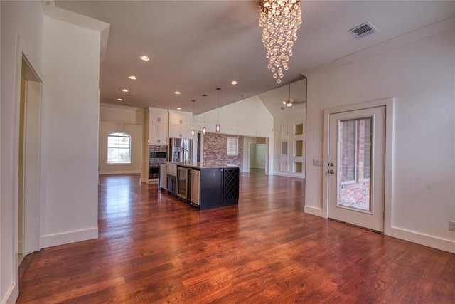 kitchen with visible vents, open floor plan, an inviting chandelier, stainless steel fridge, and dark wood-style flooring