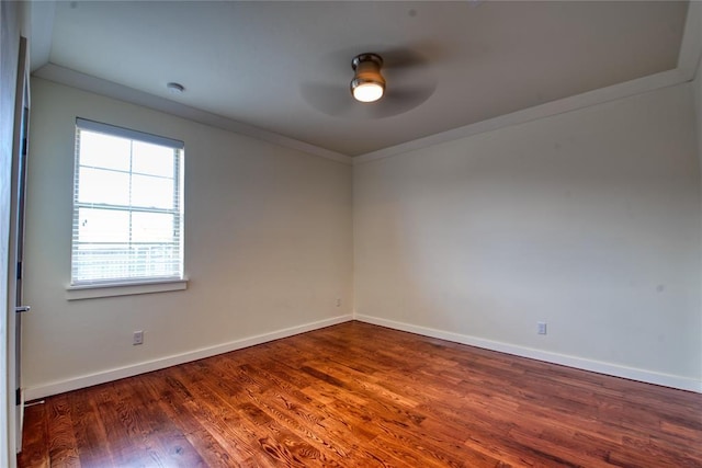 empty room with baseboards, crown molding, ceiling fan, and wood finished floors