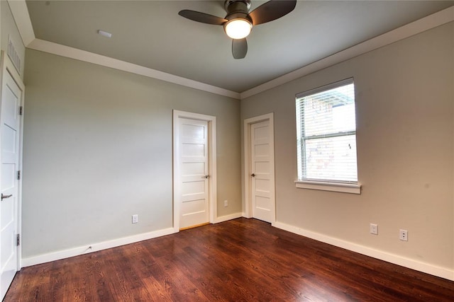 unfurnished bedroom with crown molding, dark wood-style floors, baseboards, and ceiling fan