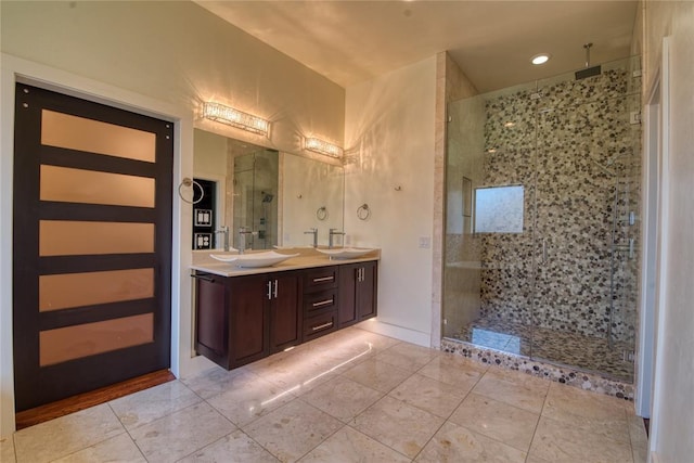 full bath featuring tile patterned flooring, a shower stall, double vanity, and a sink