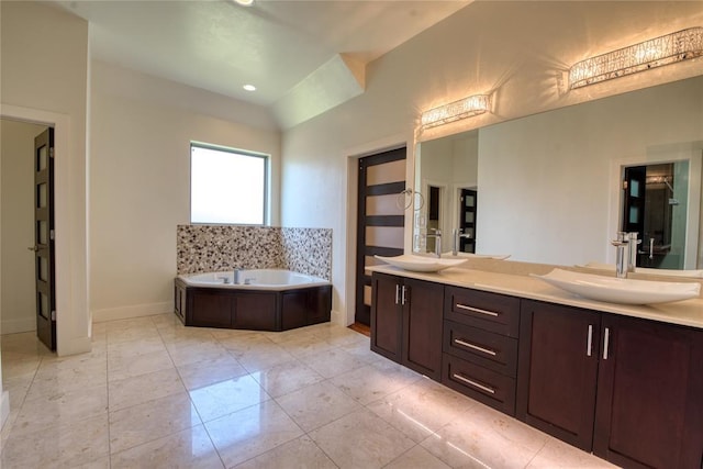 full bath with a sink, a bath, and double vanity