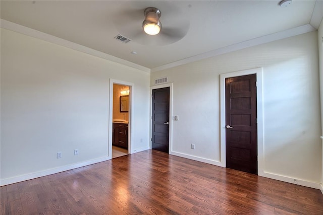 unfurnished bedroom featuring crown molding, wood finished floors, visible vents, and baseboards