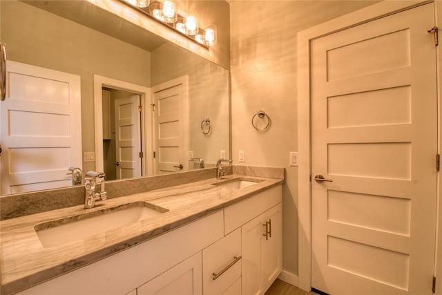 bathroom with double vanity, baseboards, and a sink