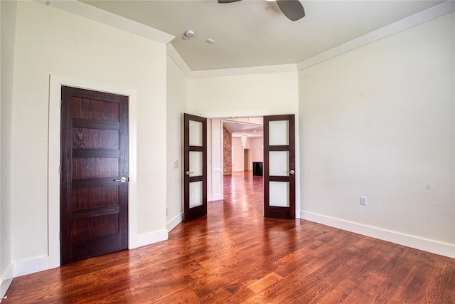 empty room with ornamental molding, baseboards, ceiling fan, and wood finished floors