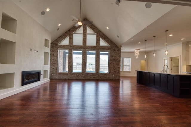 unfurnished living room featuring visible vents, high vaulted ceiling, dark wood finished floors, ceiling fan, and a glass covered fireplace