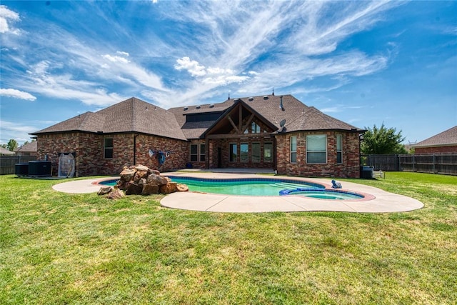 view of swimming pool with a pool with connected hot tub, fence, cooling unit, a yard, and a patio area