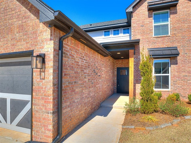 entrance to property featuring brick siding and a garage