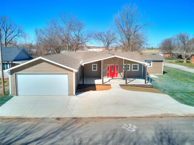 ranch-style home with an attached garage, fence, and driveway