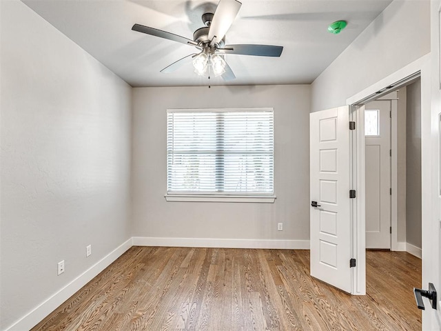 unfurnished room with plenty of natural light, wood finished floors, baseboards, and ceiling fan