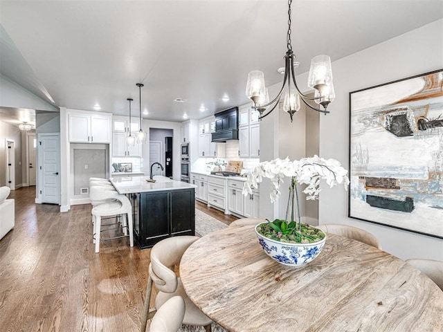 dining room featuring recessed lighting, baseboards, an inviting chandelier, and wood finished floors