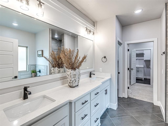 bathroom featuring a sink, a spacious closet, double vanity, and tile patterned flooring